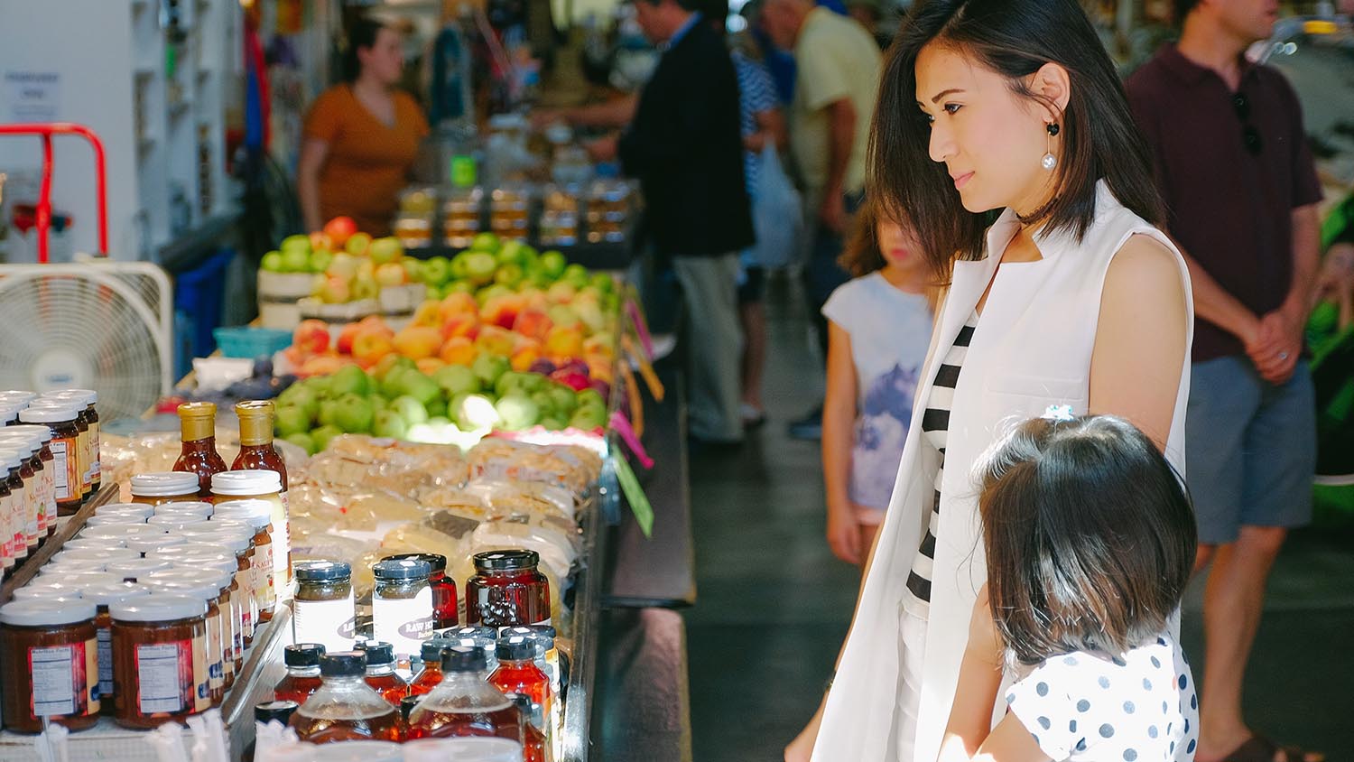 A young woman and her child shopping at a farmers market