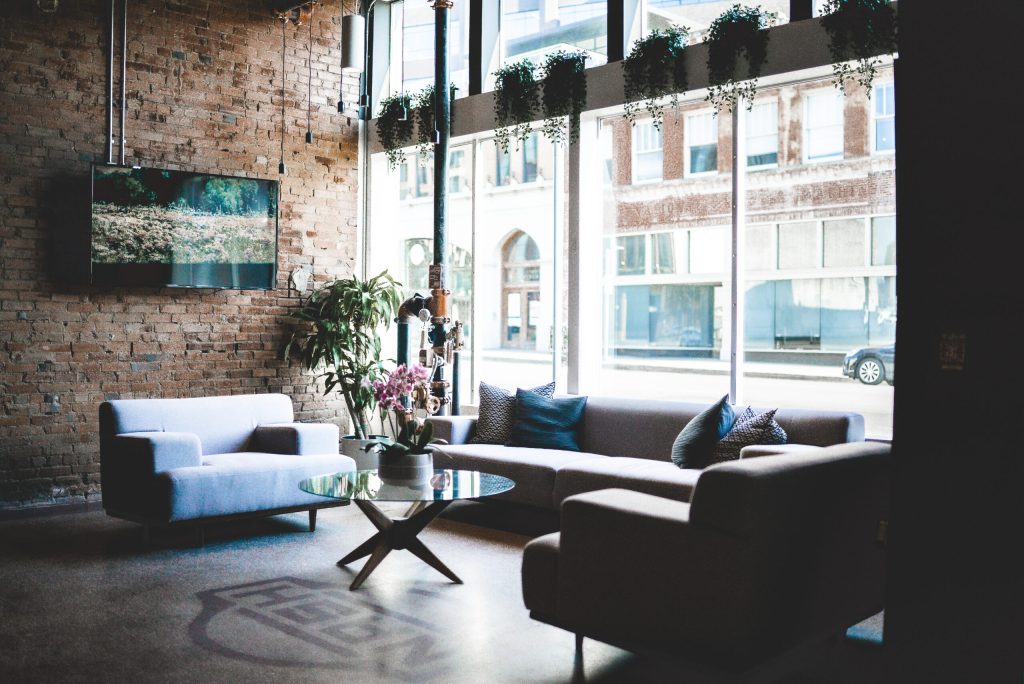 Lobby area with couches and TV near the front window of the SOVA Hotel.